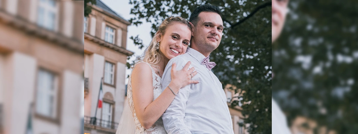 Ein Foto wo das Brautpaar kuschelnd romantisch in die Kamera schaut